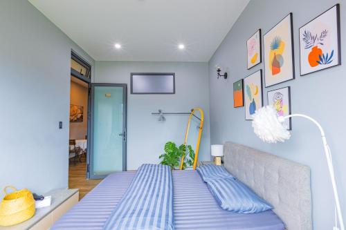 a bed in a room with blue walls at Green House - Căn hộ có bếp riêng in Da Lat