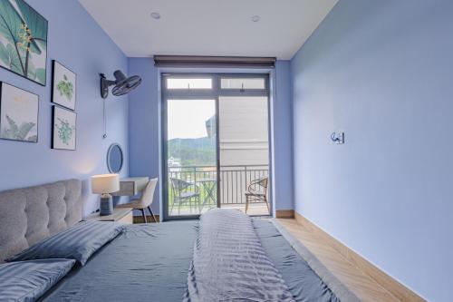 a bedroom with a bed and a balcony at Green House - Căn hộ có bếp riêng in Da Lat