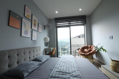 a bedroom with a large bed with a large window at Green House - Căn hộ có bếp riêng in Da Lat