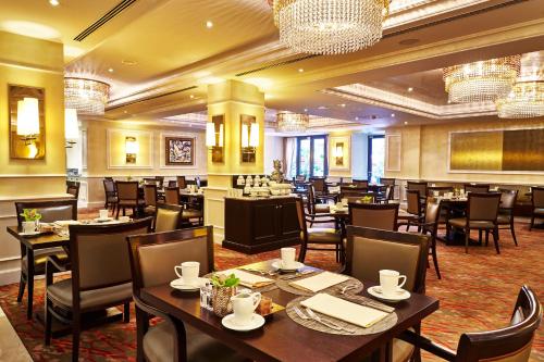 a restaurant with tables and chairs and chandeliers at Steigenberger Icon Frankfurter Hof in Frankfurt/Main