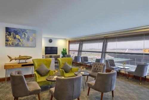 a room with chairs and tables and a large window at Sama-Sama Express KLIA Terminal 1 - Airside Transit Hotel in Sepang