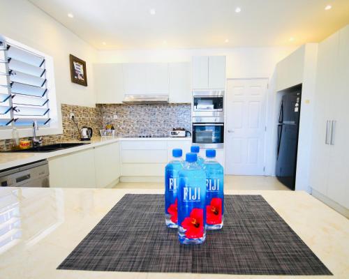 three water bottles sitting on top of a kitchen counter at Happiness Home FiJi in Narewa