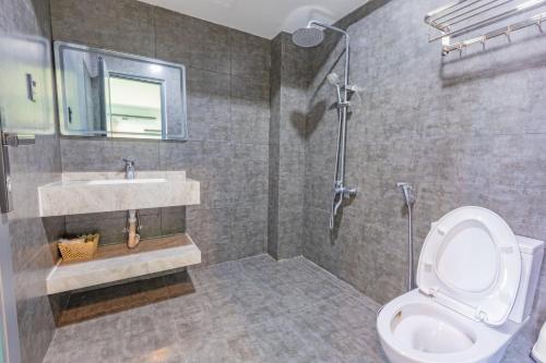 a bathroom with a toilet and a sink and a shower at Green House - Căn hộ có bếp riêng in Da Lat