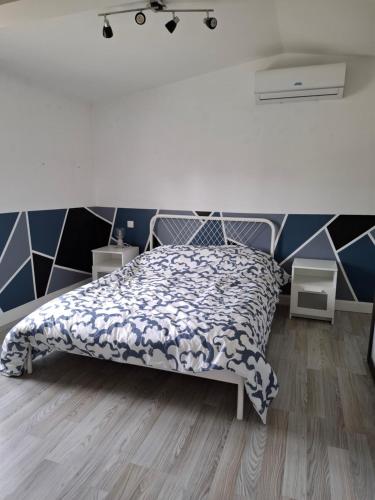 een slaapkamer met een bed met een zwart-wit dekbed bij Ateka Dax appartement in Dax