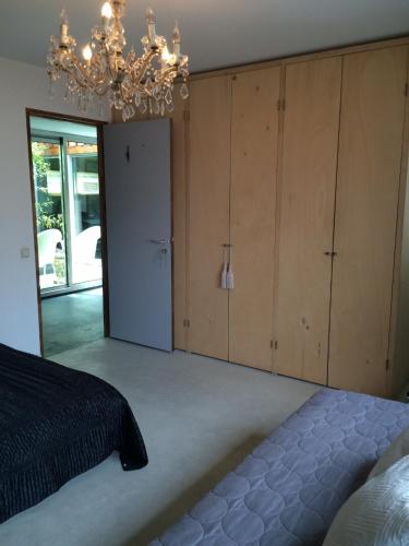 a bedroom with a bed and a chandelier at B&B Habitat in Beverwijk