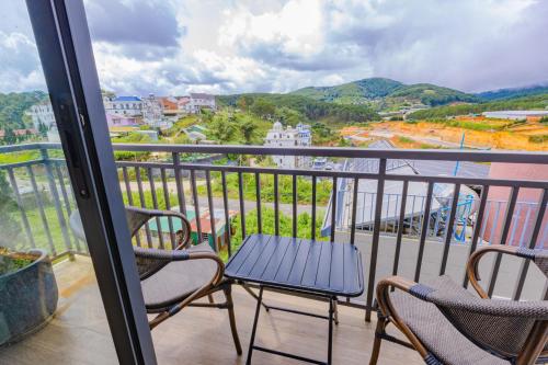 a balcony with two chairs and a table at Green House - Căn hộ có bếp riêng in Da Lat