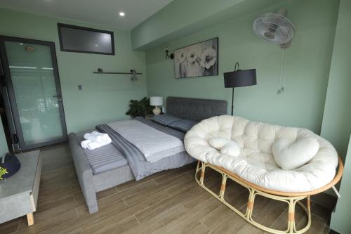 a living room with a bed and a white couch at Green House - Căn hộ có bếp riêng in Da Lat