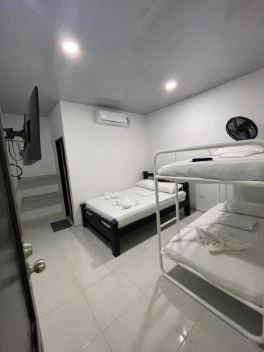 a room with two bunk beds and a tv at HOTEL HOUSE San Antero Córdoba in San Antero