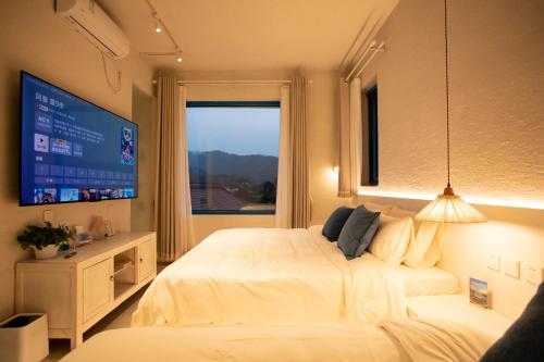 a bedroom with two beds and a large window at 北京怀柔方糖民宿 in Sanduhe