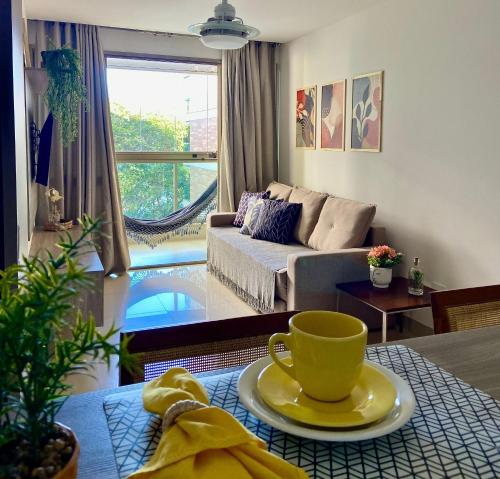 a living room with a yellow coffee cup on a table at Blue Hope by Mosaico Stays in Vitória