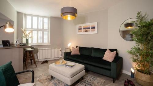 a living room with a green couch and a table at Easy Reach in Ambleside