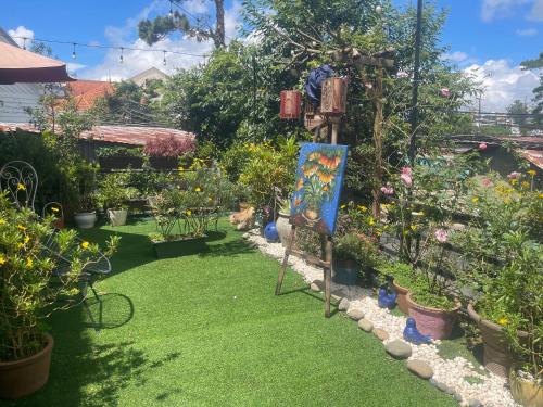 a garden with plants and a painting in the grass at Redhouse Dalat Hotel in Da Lat