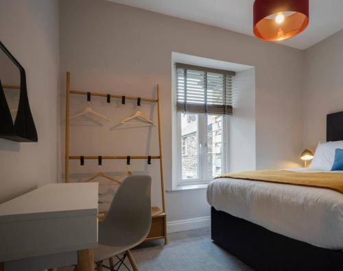 a bedroom with a bed and a desk and a window at Cosy Nook in Windermere