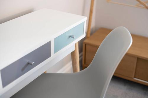 a white chair sitting next to a desk with a drawer at Cosy Nook in Windermere