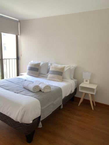 a bedroom with a large bed with towels on it at Departamento San Fernando in San Fernando