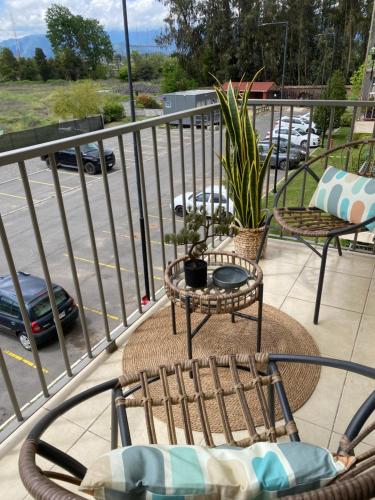 a balcony with chairs and a table and a parking lot at Departamento San Fernando in San Fernando
