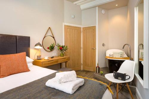 a bedroom with a bed and a desk and a mirror at No 1, Midland Bank Chambers in Ambleside