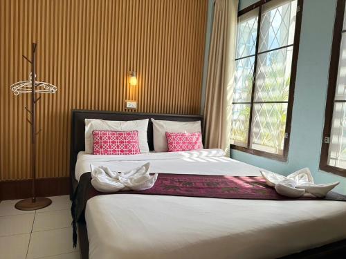 a bedroom with a large bed with pink and white pillows at Mixay Paradise Hotel in Vientiane