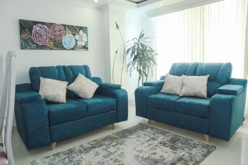 a blue couch and two chairs in a living room at El Descanso del Sol in Sogamoso