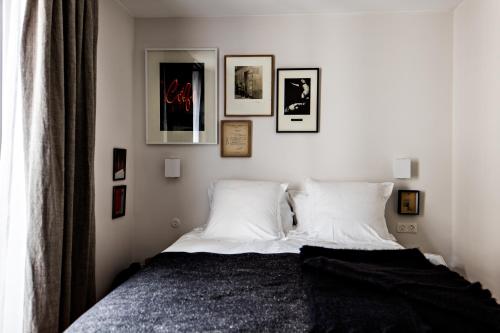 - une chambre dotée d'un lit avec des oreillers blancs et des photos murales dans l'établissement Le Pigalle, a Member of Design Hotels, à Paris