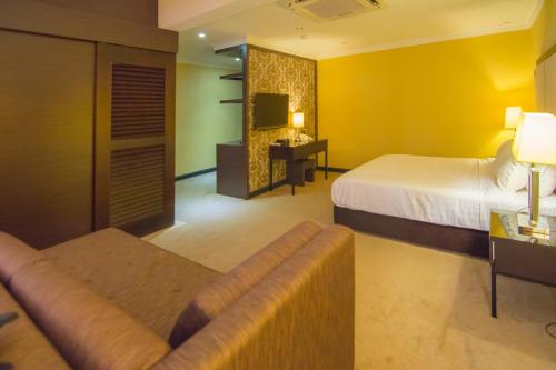 a hotel room with a bed and a couch at Merdeka Hotel Kluang in Kluang