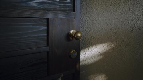a door with a brass door knob on a wall at 旧雨今雨 in Onomichi