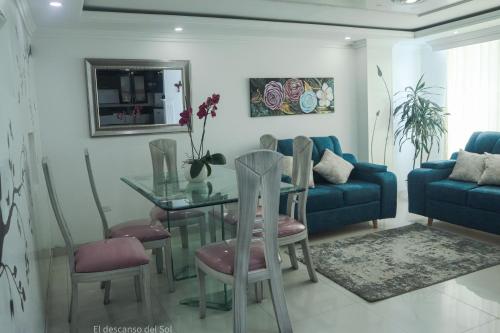 a living room with a table and a blue couch at El Descanso del Sol in Sogamoso
