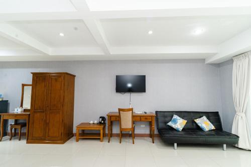 a living room with a couch and a table at Baan Suan Khun Ta and Golf Resort in Ubon Ratchathani