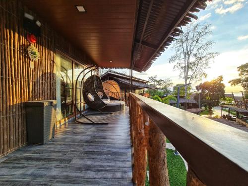 a porch of a building with chairs on it at Crusoe Cabins Costa Azalea in Davao City