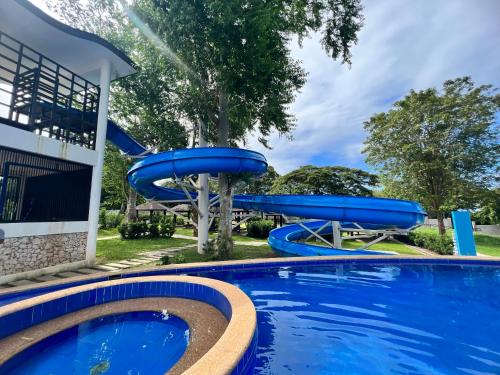 a pool with a water slide in a yard at Crusoe Cabins Costa Azalea in Davao City