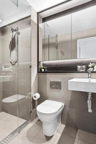 a bathroom with a toilet and a sink and a shower at Orange Stay at Melbourne Quarter in Melbourne