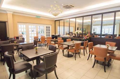 a dining room with tables and chairs in a restaurant at Merdeka Hotel Kluang in Kluang