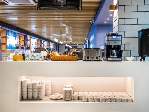 a store with a shelf filled with white cups at 利怡酒店汕头高铁站万象城店 in Ma Yu