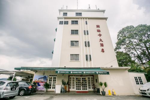 a tall white building with writing on it at Merdeka Hotel Kluang in Kluang