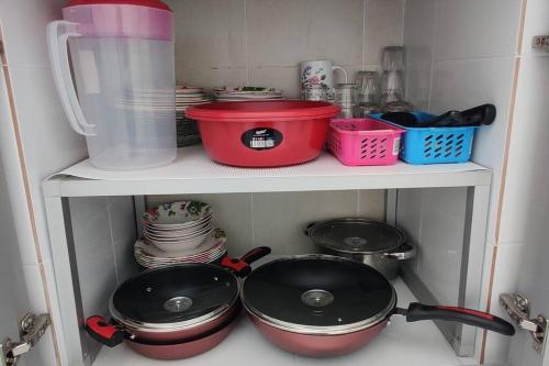 a kitchen with pots and pans on a shelf at AKASIA Homestay Segamat in Segamat