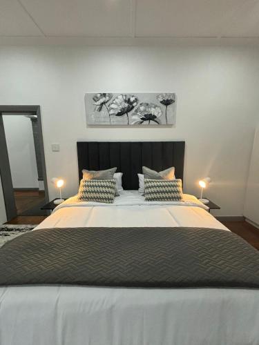 a bedroom with a large bed with two lamps at 30 on 6th in Bellville