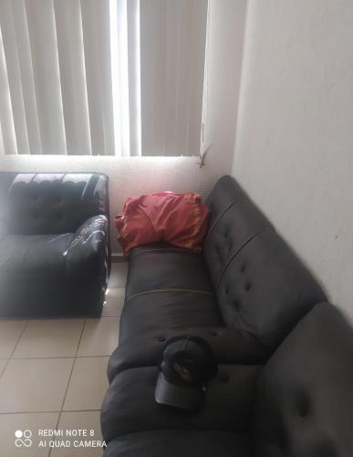 a black leather couch in a living room at Casa real del palmar in La Sabana