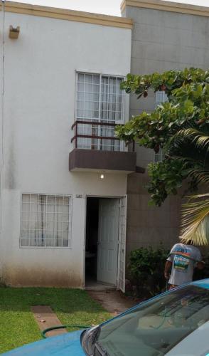 a man standing outside of a white house at Casa real del palmar in La Sabana