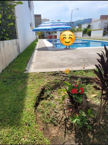 a smiley face infront of a pool with an umbrella at Casa real del palmar in La Sabana