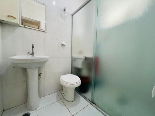 a bathroom with a toilet and a sink and a shower at Itararé um sonho de mar in São Vicente