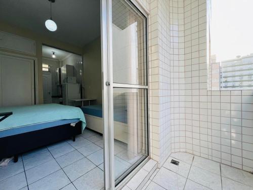a bathroom with a shower and a bed in a room at Itararé um sonho de mar in São Vicente