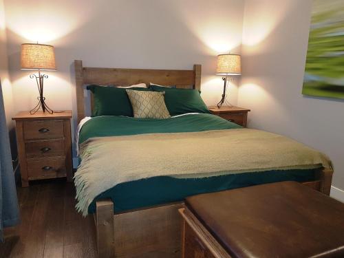 a bedroom with a bed with two nightstands and two lamps at Peachland Lake View Spectacular! in Peachland
