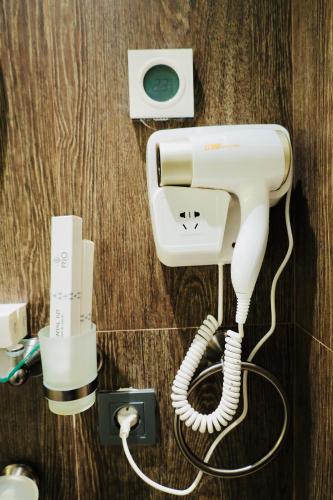 a white phone is plugged into a wall at RIO Hotel in Samarkand