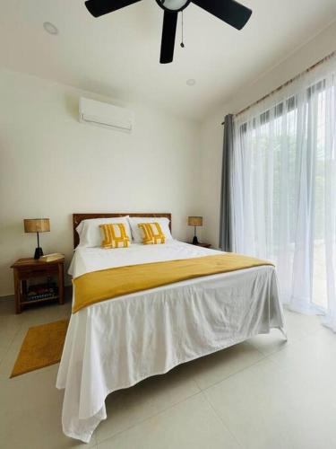 a bedroom with a bed with a ceiling fan at Casa Paloma in Playa Grande