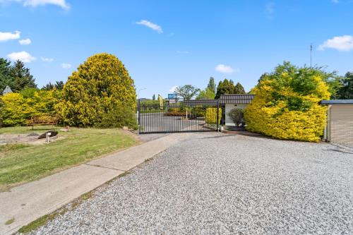 an empty driveway with a gate in a yard at Tally Ho Motor Inn in Tenterfield