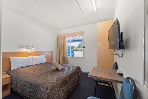 a hotel room with a bed and a television at Tally Ho Motor Inn in Tenterfield