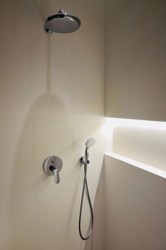 a shower in a white bathroom with a shower head at RIO Hotel in Samarkand