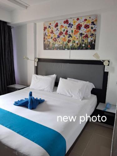 a blue teddy bear sitting on top of a bed at Boomerang Inn in Patong Beach