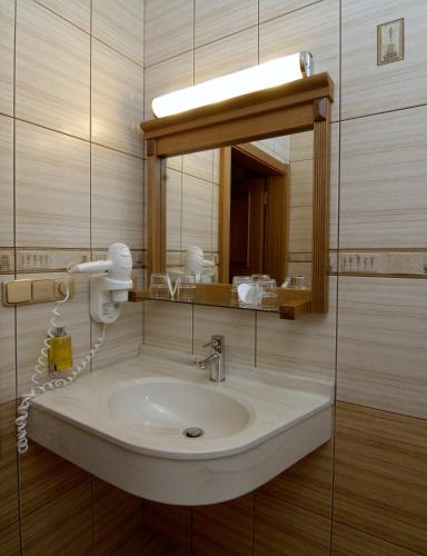 a bathroom with a sink and a mirror at Wellness Hotel Windsor in Špindlerův Mlýn