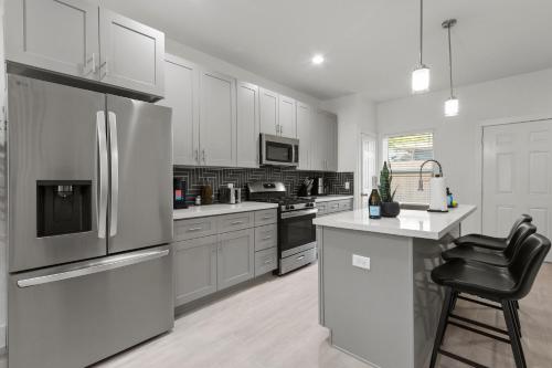 a kitchen with stainless steel appliances and white cabinets at Stylish 3 Bedroom Rental - Just Minutes from Dowtown Houston in Houston